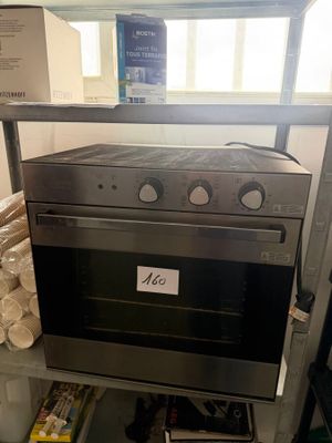 a silver oven that is on a shelf in a room