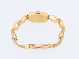 an 18k yellow gold bracelet watch with a white diamond