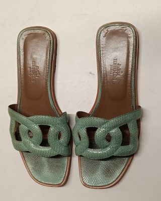 a pair of green sandals on a white surface