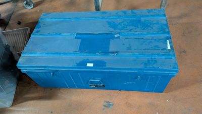 a blue box sitting on the floor next to a chair