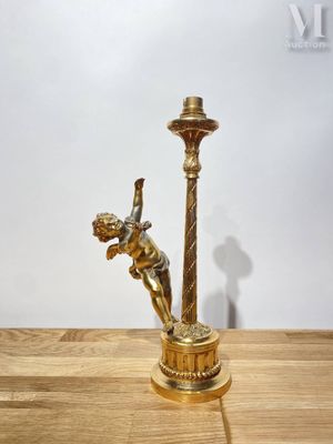 un bougeoir en or posé sur une table en bois, avec une bougie