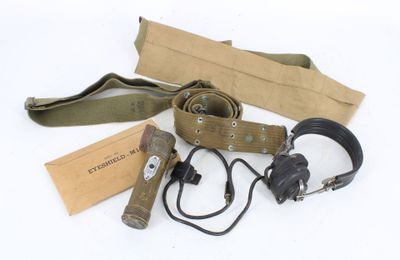 an assortment of military items including a belt, headphones, and a book
