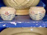 deux bols et un vase posés sur une étagère dans un meuble bleu