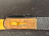 a close up of a black bag with a yellow handle