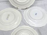 three white plates with designs on them are sitting on a table