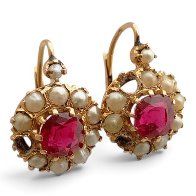 une paire de boucles d'oreilles en rubis et perles sur fond blanc