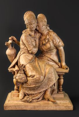une photo représentant une statue de deux femmes assises sur un banc
