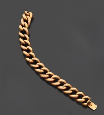 un bracelet en chaîne d'or muni d'un fermoir, posé sur un fond noir
