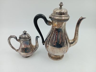 une théière en argent et une théière en argent posées sur une table blanche