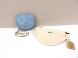 a blue purse and a white bag on a table