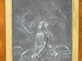 une image représentant une plaque métallique sur laquelle figurent une femme et un chien