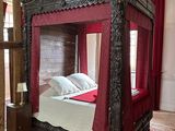 a bed with a red canopy in the middle of a room