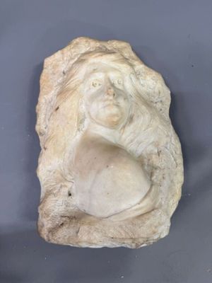 une statue représentant une femme assise sur un rocher