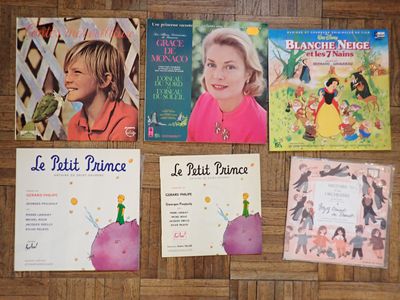 Plusieurs livres pour enfants sont alignés sur un plancher en bois