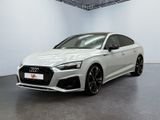 Une Audi RS4 blanche est garée dans une grande pièce