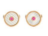 un gros plan sur une paire de boutons de manchette roses et blancs
