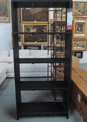 a black shelf with a glass door in the middle of a room