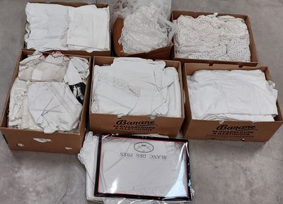 several boxes of white clothing are sitting on the floor