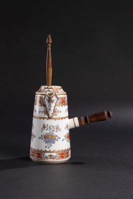 une théière avec une poignée en bois posée sur une table