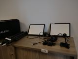 deux ordinateurs portables posés sur un bureau, avec un sac par-dessus
