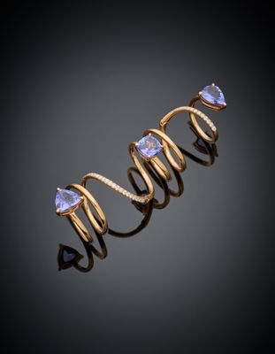 gros plan d'une bague en or avec une pierre violette