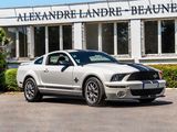 a white mustang parked in front of a building