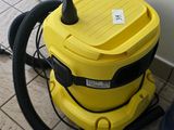 a yellow vacuum cleaner sitting on the floor next to a trash can