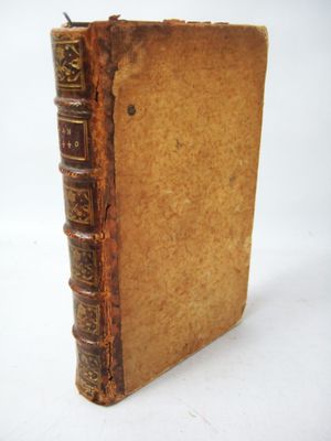 an old book sitting on top of a white table next to a white wall