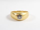 gros plan d'une bague en or avec un diamant au centre
