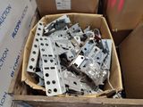 a cardboard box full of metal parts in it