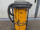 a yellow dust collector with a hose attached to it