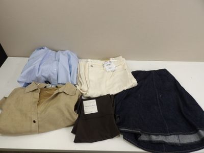 several pairs of men ' s shirts and pants sitting on a white table