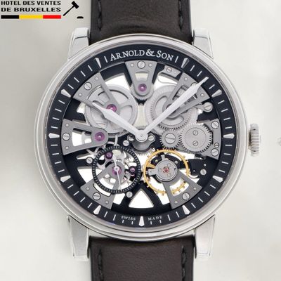 une image d'un gros plan d'une montre sur une surface blanche
