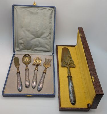 quatre pièces d'argenterie dans un coffret posé sur une table