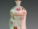 a white vase with a pink and green design on it