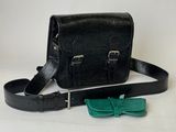 black leather bag with bow tie and glasses on white background