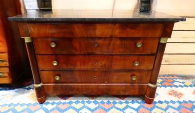 a wooden chest of drawers with a marble top