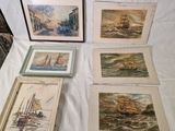 quatre photos encadrées représentant des bateaux, posées sur une table blanche