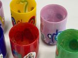 many different colored cups sitting next to each other on a table