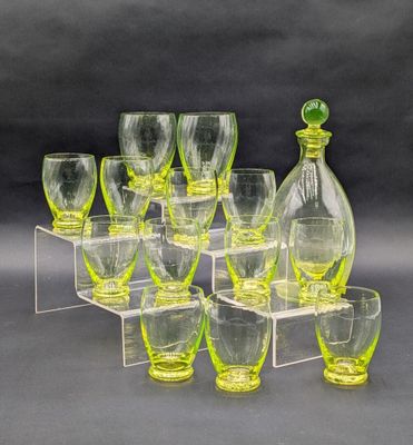 des bouteilles et des verres sont alignés sur une étagère transparente