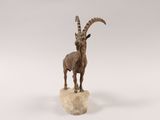 an image of a statue of a goat standing on top of a rock