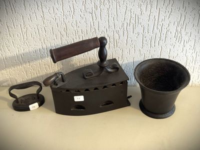 un vieux fer à repasser et une tasse posés sur une table