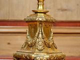 a gold candle on a marble table with a wood paneled wall in the background
