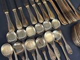 a lot of silver spoons and spoons on a table