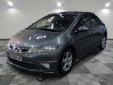 La Honda Civic grise est garée dans le garage, sur un sol à damier.