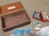 a wooden box filled with money and other items on the floor