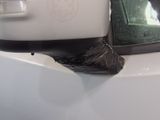 a trash bag sitting on the side of a white car