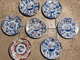 six assiettes bleues et blanches sont disposées en cercle sur un sol carrelé