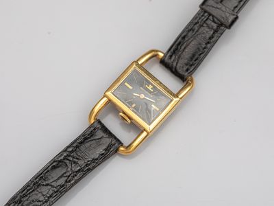 a close up of a watch on a white surface with a black strap