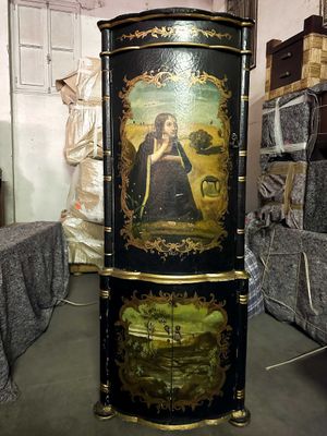 a black cabinet with a painting on it in a room